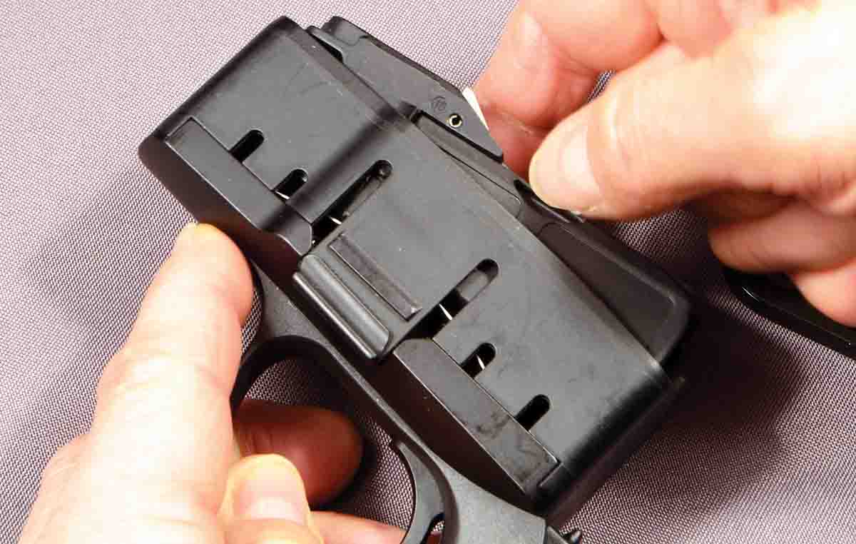 Simply pushing on the thumb slot of the magazine insert releases the locking studs.